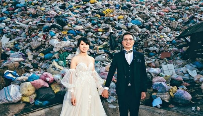 Green couple embraces garbage wedding shoot